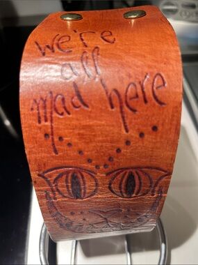 Handcrafted Brown Leather Wrist Art with Engraved Cheshire Cat Design